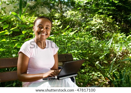 african american student studying computer in the park