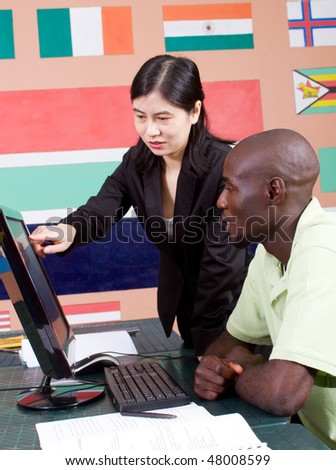female chinese teacher teaching computer to african student