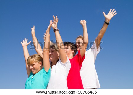 family of four arms open over blue sky background
