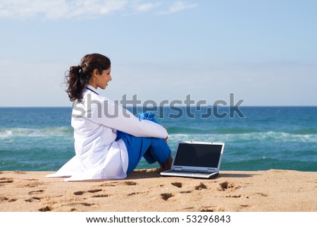 young medical doctor with laptop on beach