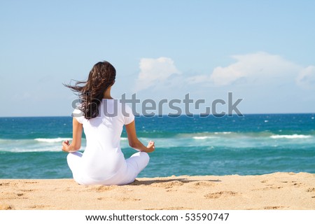 young beautiful woman meditation on beach