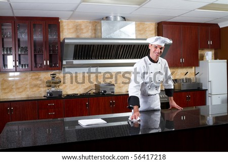 young male professional chef cleaning in commercial kitchen