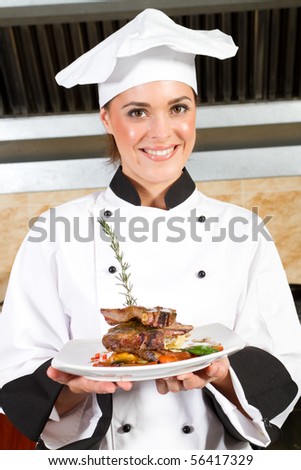 young beautiful female chef presenting food in kitchen