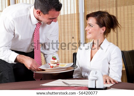 friendly male waiter brings to the customer the ordered dessert