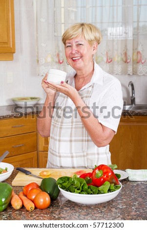 senior woman drinking tea or coffee in kitchen
