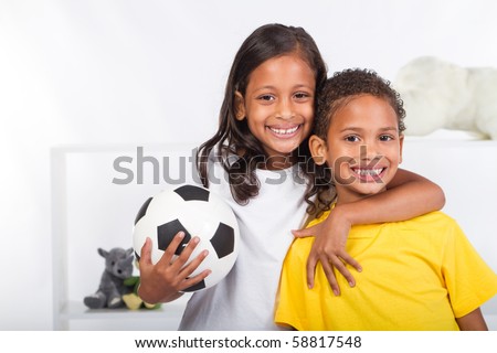brother and sister holding a soccer ball