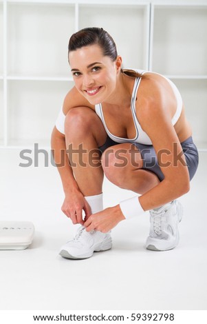 young fitness woman tie her shoes