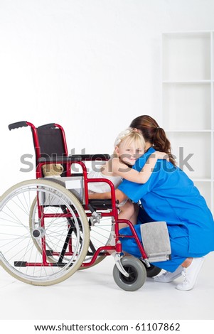 little girl patient on wheelchair hugging doctor
