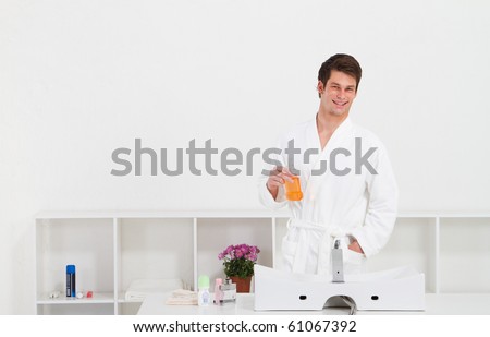 young man in bathroom with mouth wash bottle