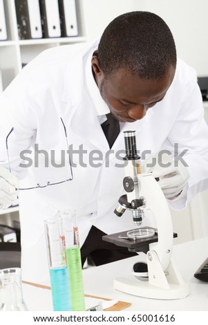 african american male lab researcher looking through microscope