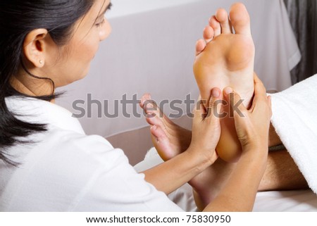 asian woman giving professional foot massage