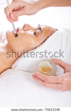 young woman having a honey facial at spa salon