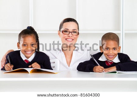 caring primary teacher and students in classroom