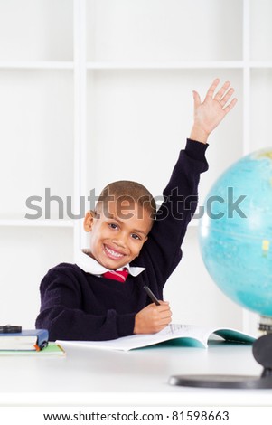 first grade student raising his hands in classroom