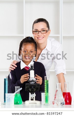 portrait of beautiful science teacher and schoolgirl in lab