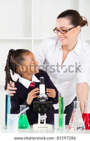 friendly teacher talking to elementary student in science class