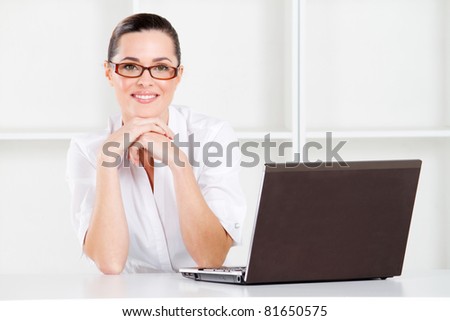 good looking young businesswoman sitting in office with laptop