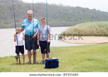 grandfather and grandsons fishing by the lake