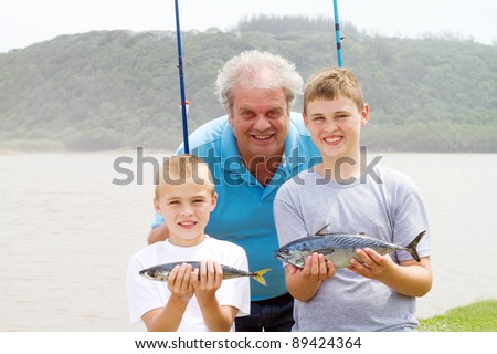 catch of the day: happy grandpa and grandson showing two fish