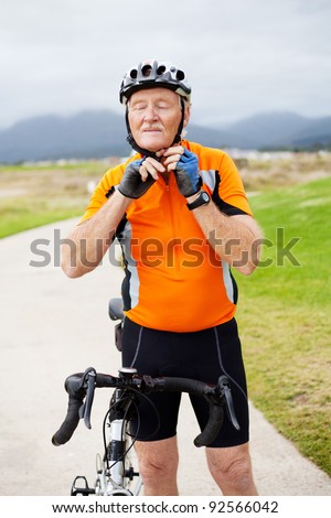 senior man putting his cycling helmet on before riding