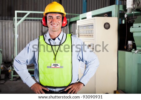 happy male industrial health and safety officer portrait inside factory