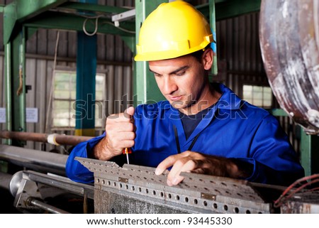 industrial mechanic repairing heavy industry machine