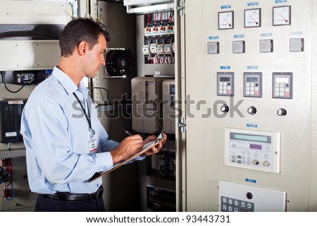 technician writing down modern computerized machine setting data