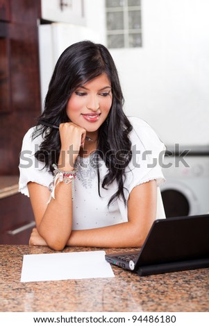 beautiful young indian woman using laptop computer at home