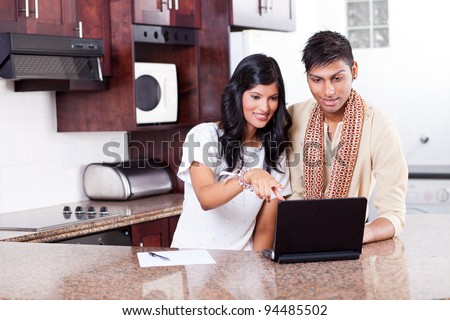 young indian couple using computer at home