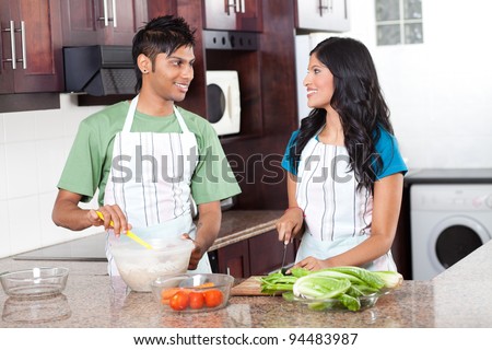 modern young indian couple cooking in kitchen