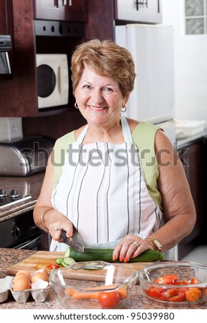 happy senior woman cooking in kitchen
