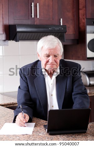 senior man doing internet banking at home and looks worried