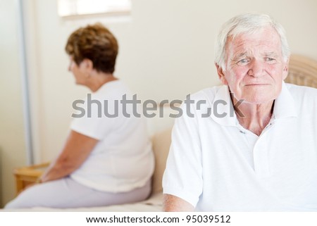unhappy senior couple sitting on bed