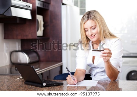 attractive young woman calculating credit card bill