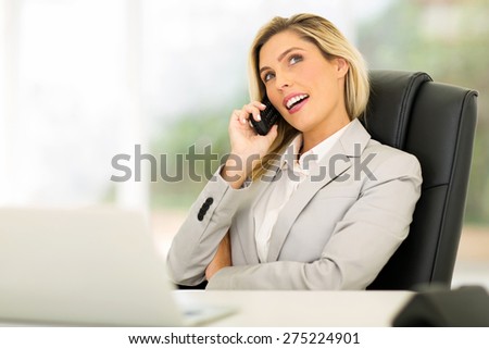 relaxed young businesswoman using telephone in office