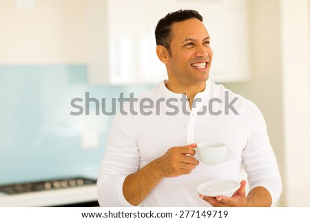 cheerful middle aged man drinking coffee at home