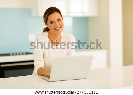 happy young woman using laptop computer at home