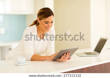 pretty young woman using tablet computer at home
