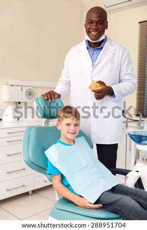 portrait of little boy and african american dentist in office