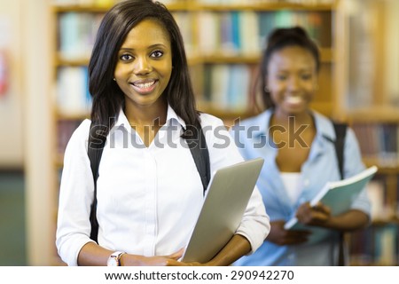 portrait of young african american college student holding laptop