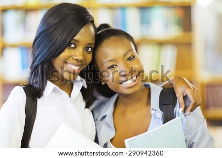 portrait of pretty african american college friends together in library