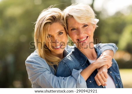 close up portrait of mother and daughter hugging