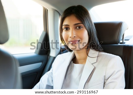 attractive young indian woman sitting inside a car