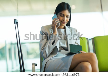 pretty female business traveler talking on cell phone at airport