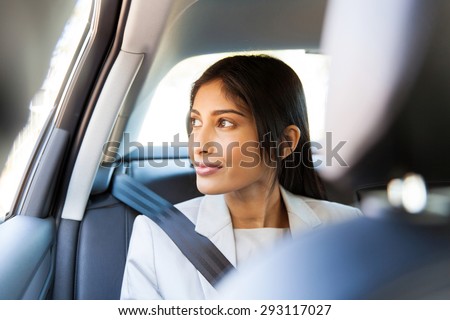 elegant indian business executive looking out of a car window