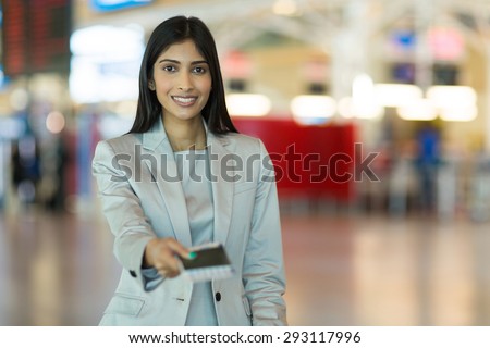happy indian woman handing over air ticket at airline check in counter