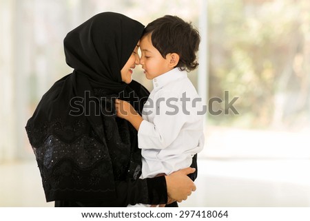 adorable middle eastern woman playing with her son at home