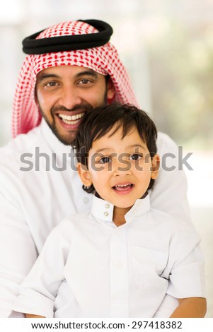 portrait of arabian father and son sitting at home