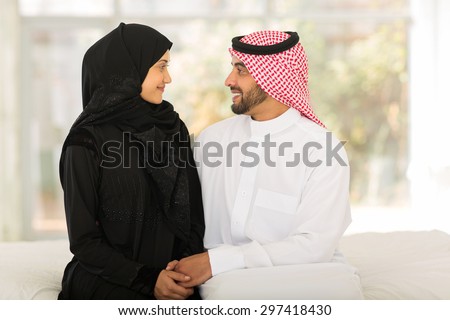 romantic arabic couple sitting on bed