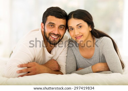 beautiful young indian married couple lying on bed